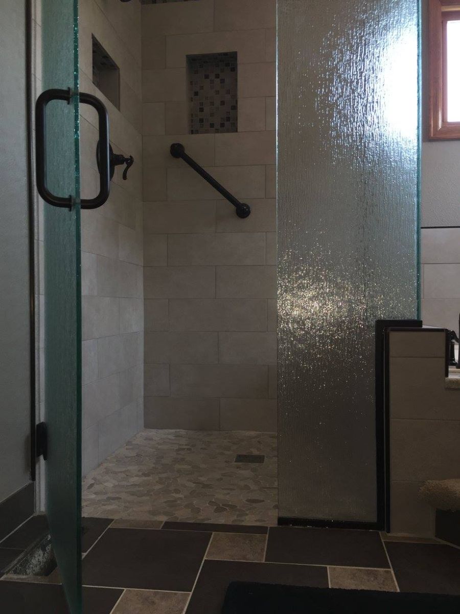 a bathroom with a walk in shower and a glass door
