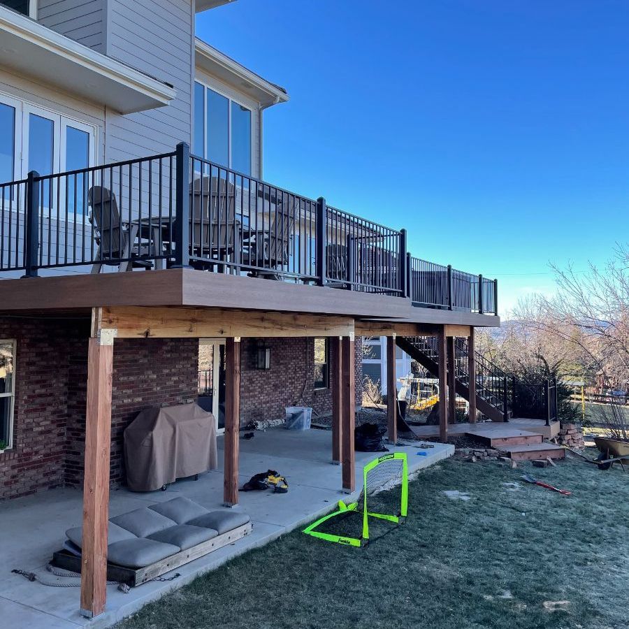 a house with a large deck with chairs and tables on it