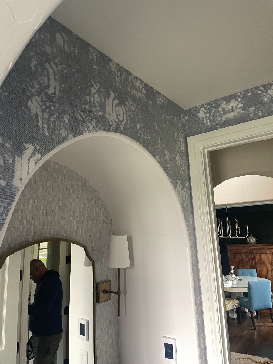 a man is standing in front of a mirror in a hallway .