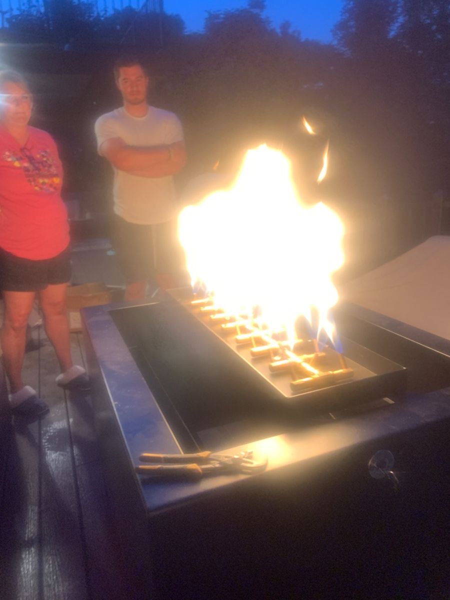 two people are standing in front of a fire pit