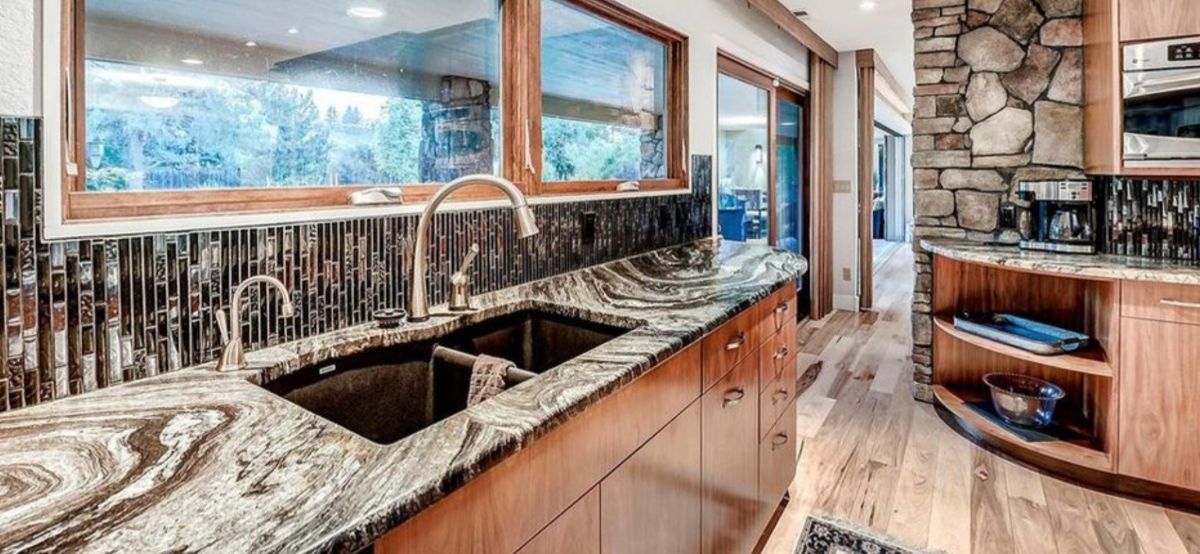 a kitchen with granite counter tops , wooden cabinets and a sink .