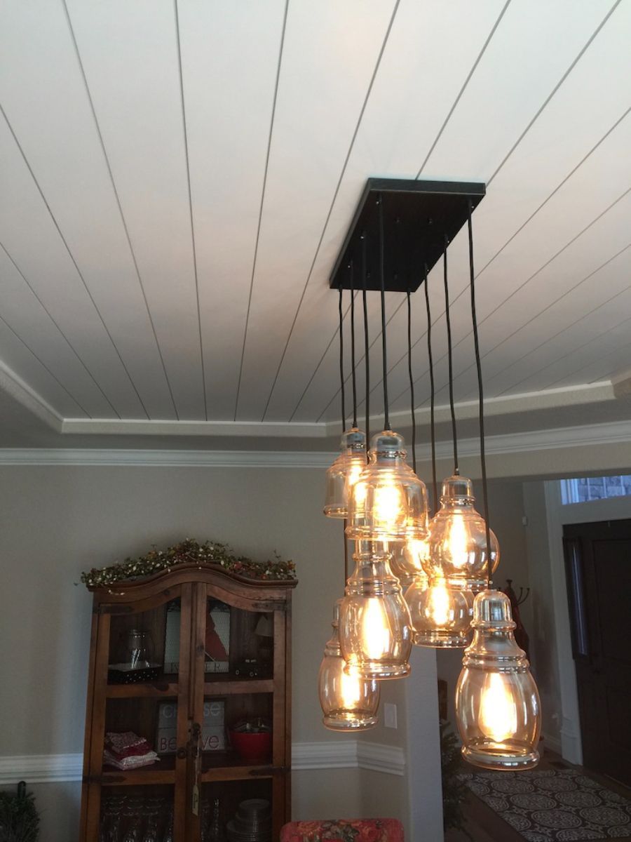 a dining room with mason jar lights hanging from the ceiling