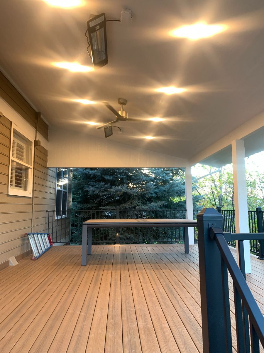 a wooden deck with a table and a ceiling fan .