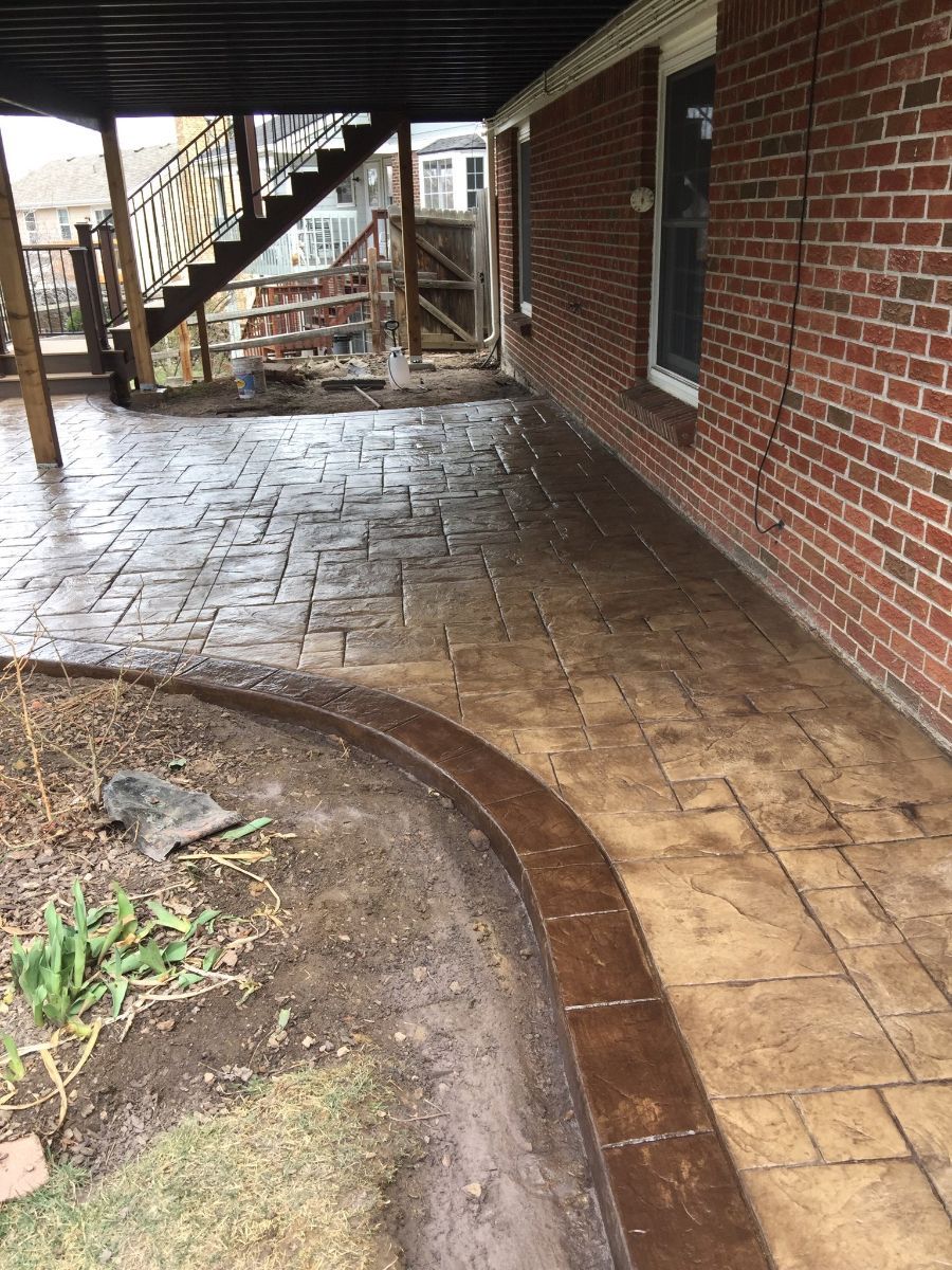 a brick house with a patio and stairs underneath it .