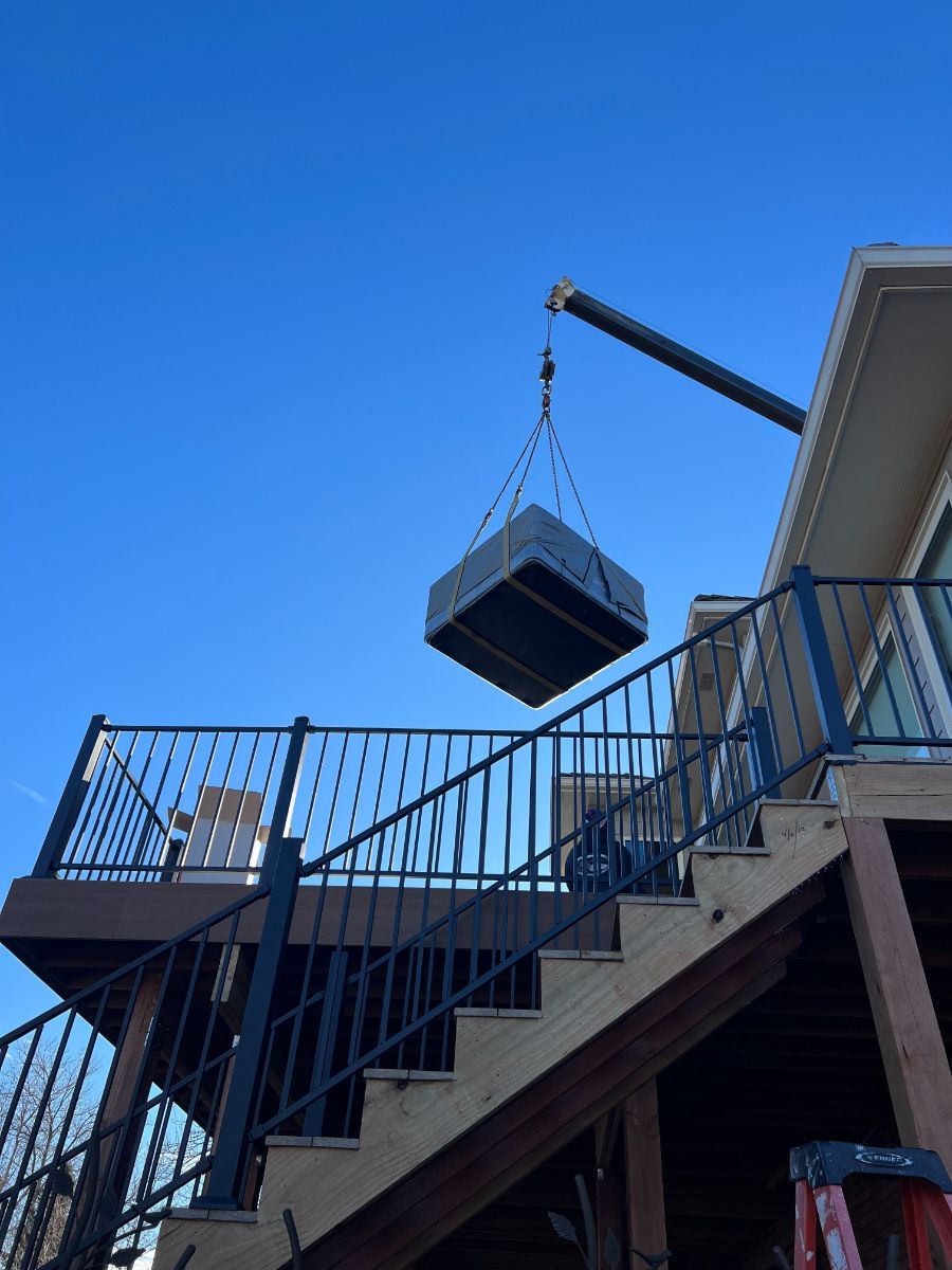 a crane is lifting a box over a set of stairs