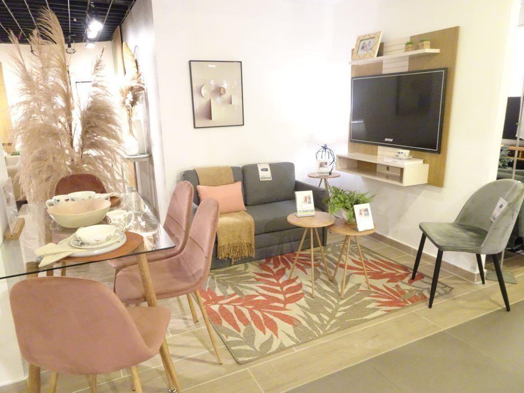 Living room with gray sofa, pink chairs, and rug with floral design.