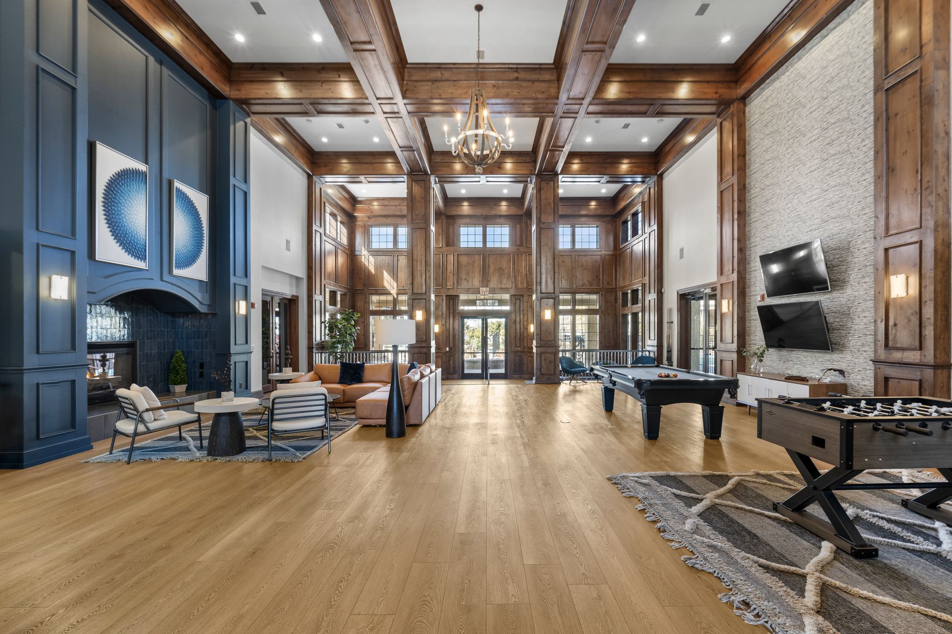 Clubhouse with high ceilings, seating areas, TV, and games.