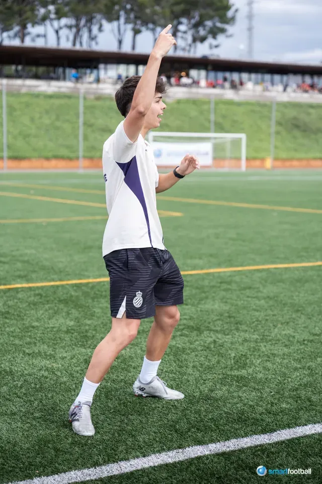 Soccer player on a field raises his arm, likely celebrating a goal or pointing.