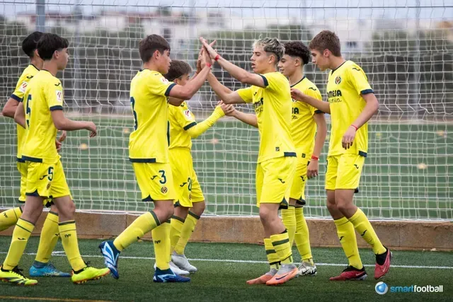 Soccer players in yellow uniforms celebrating with high-fives on a field.