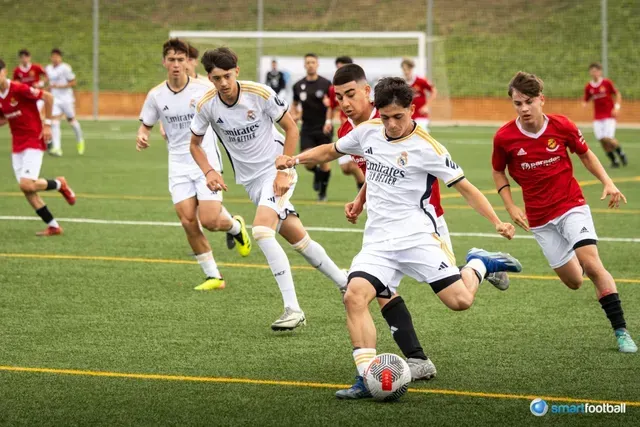 Soccer players in white and red jerseys playing on a green field.