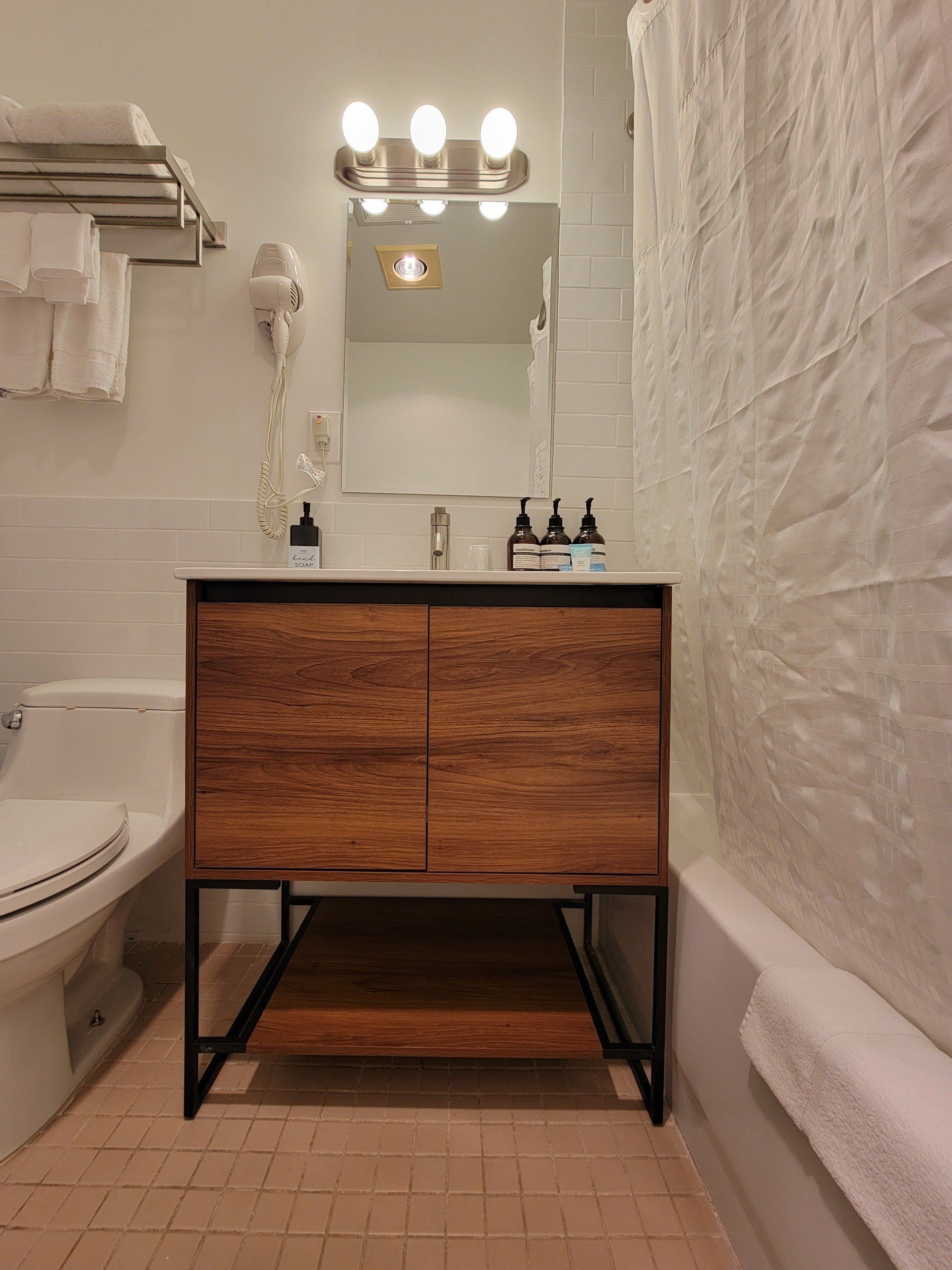 A bathroom with a toilet , sink , mirror and bathtub.
