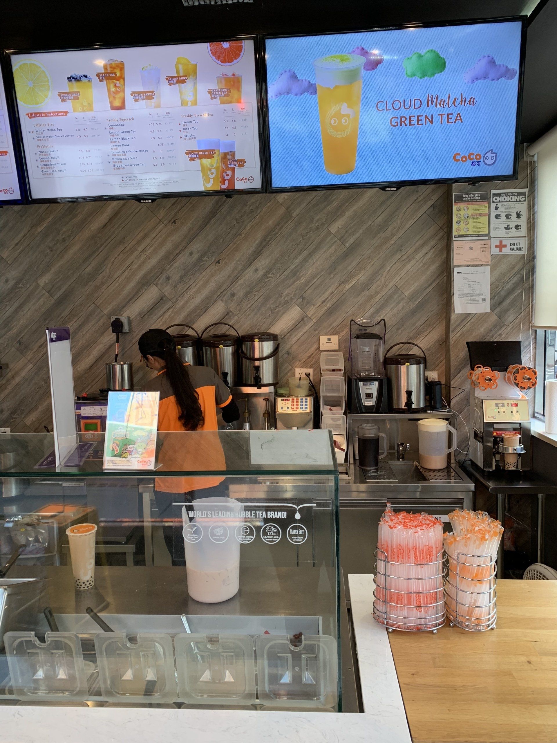 A woman is standing behind a counter in a restaurant.