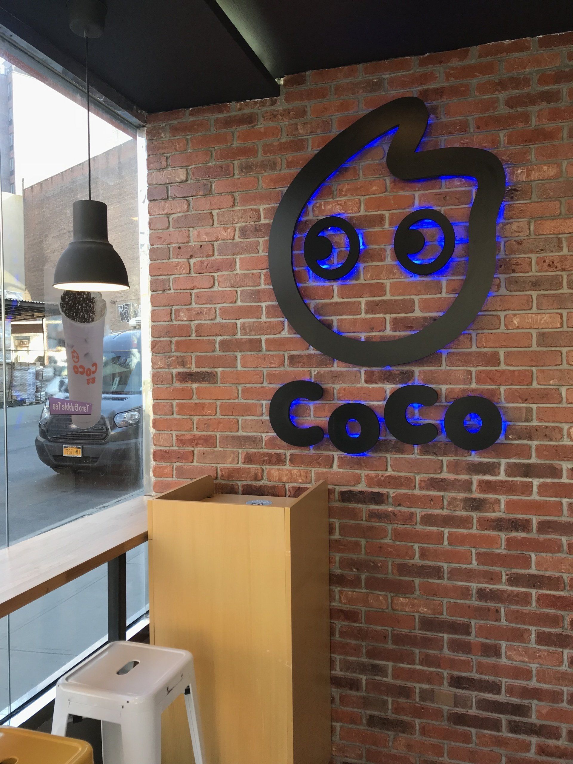 A brick wall with a sign that says coco on it