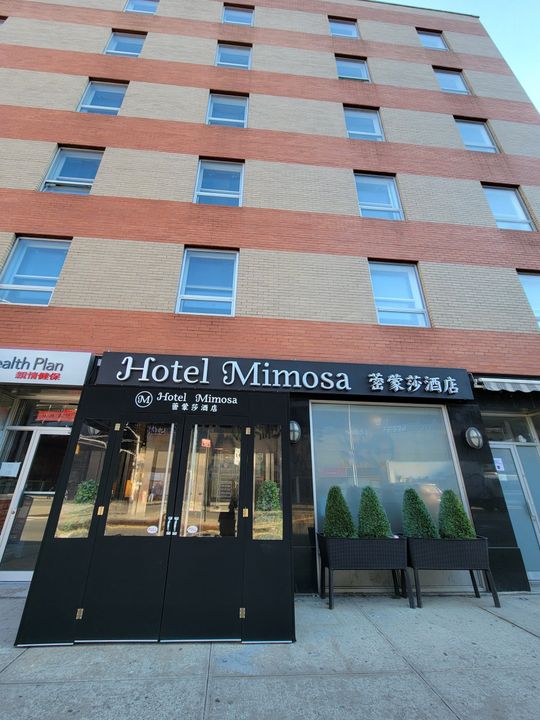 A large brick building with a sign that says hotel mimosa