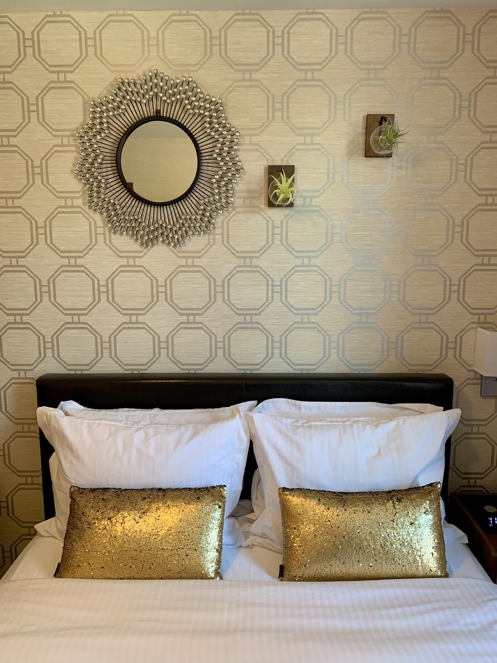 A bedroom with a bed and a mirror on the wall