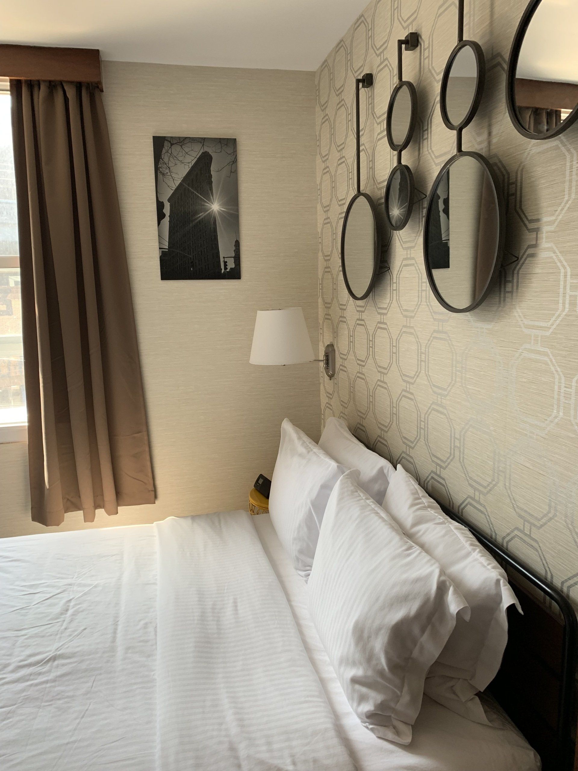 A hotel room with a bed and mirrors on the wall