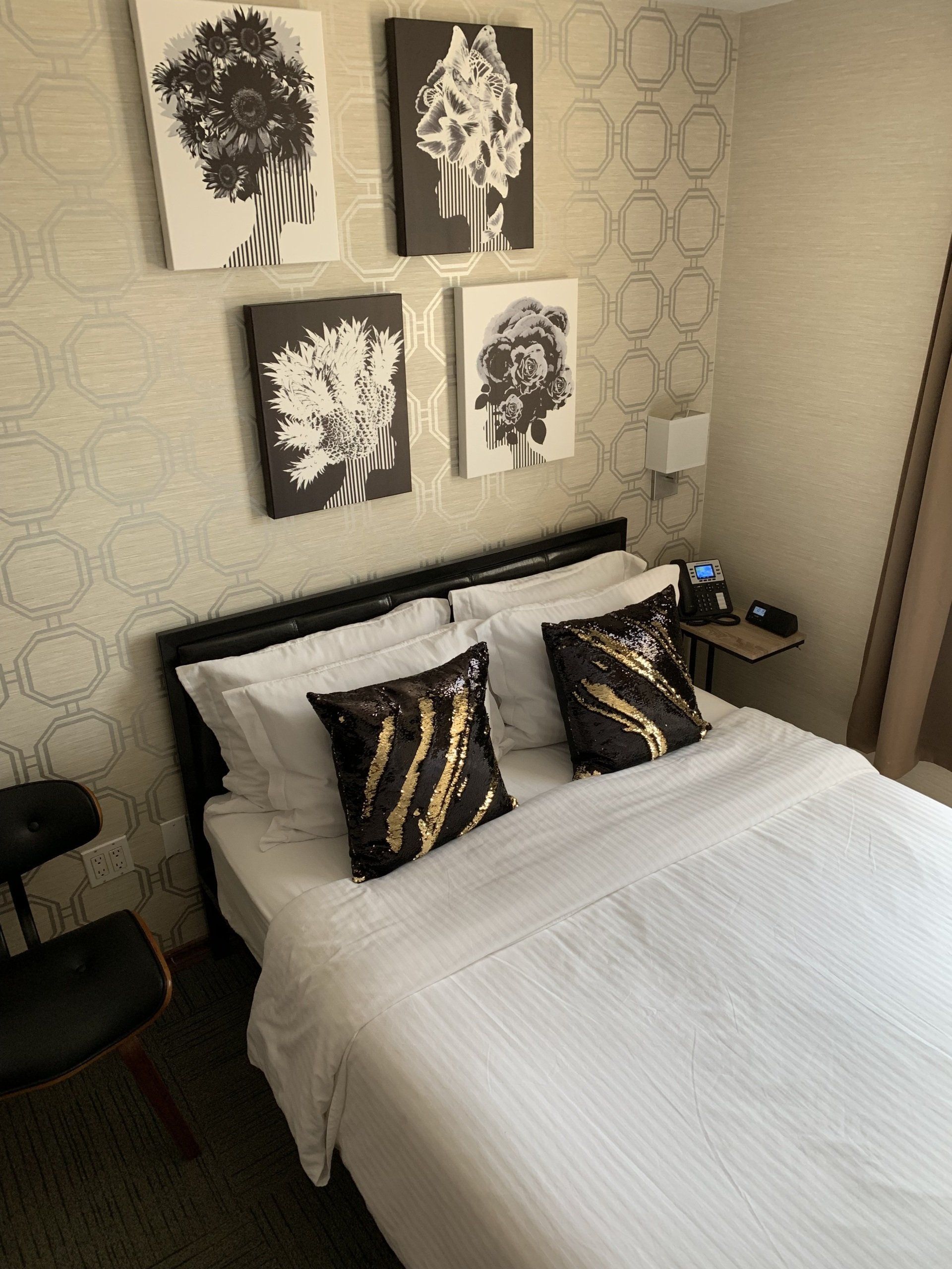 A hotel room with a bed and paintings on the wall
