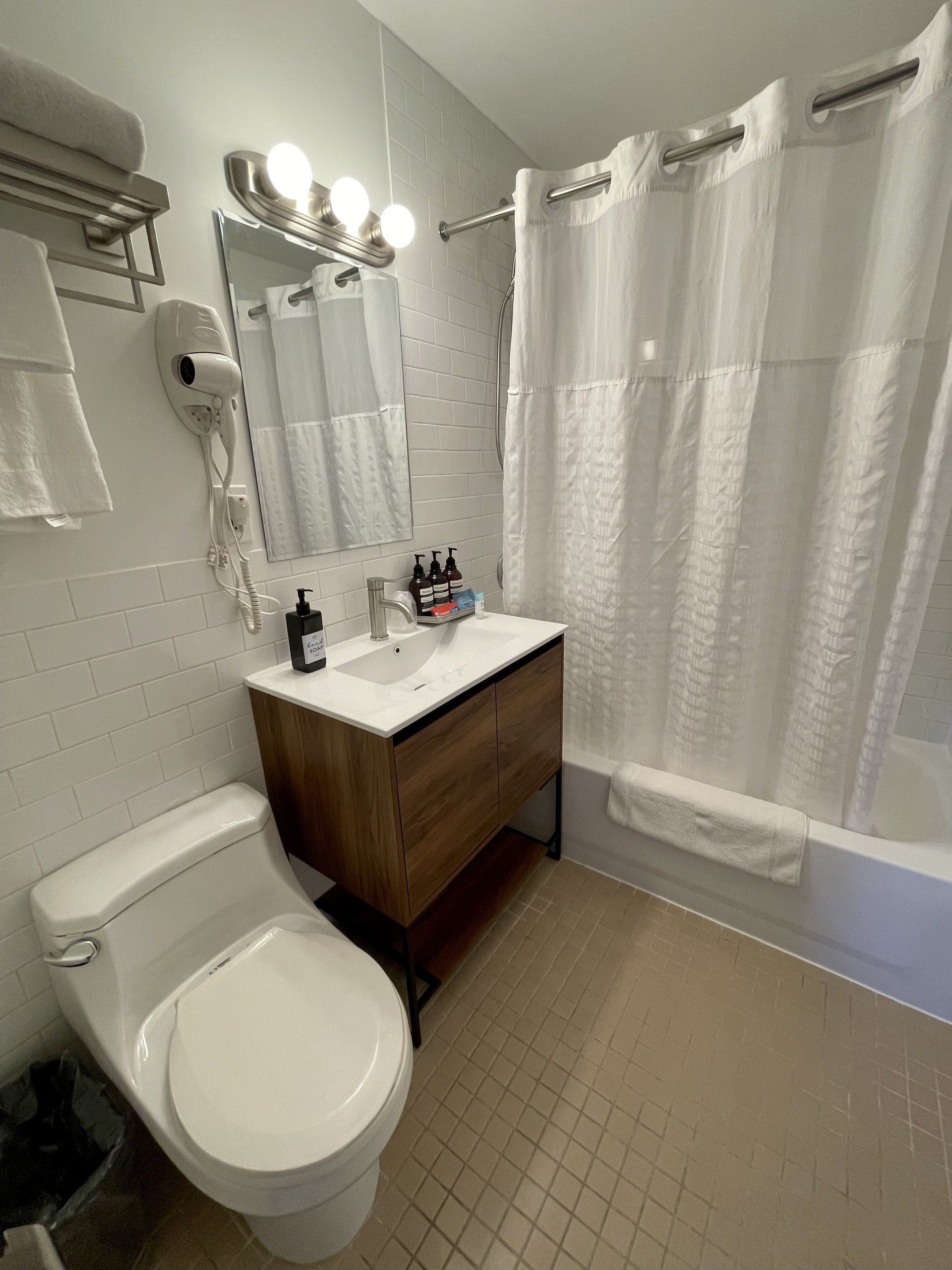 A bathroom with a toilet , sink , shower and bathtub.