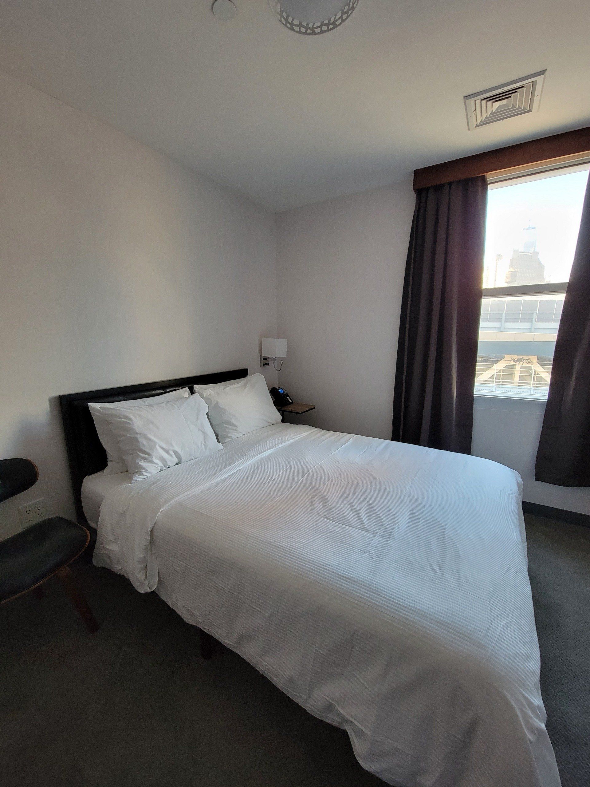 A bedroom with a large bed and a window.