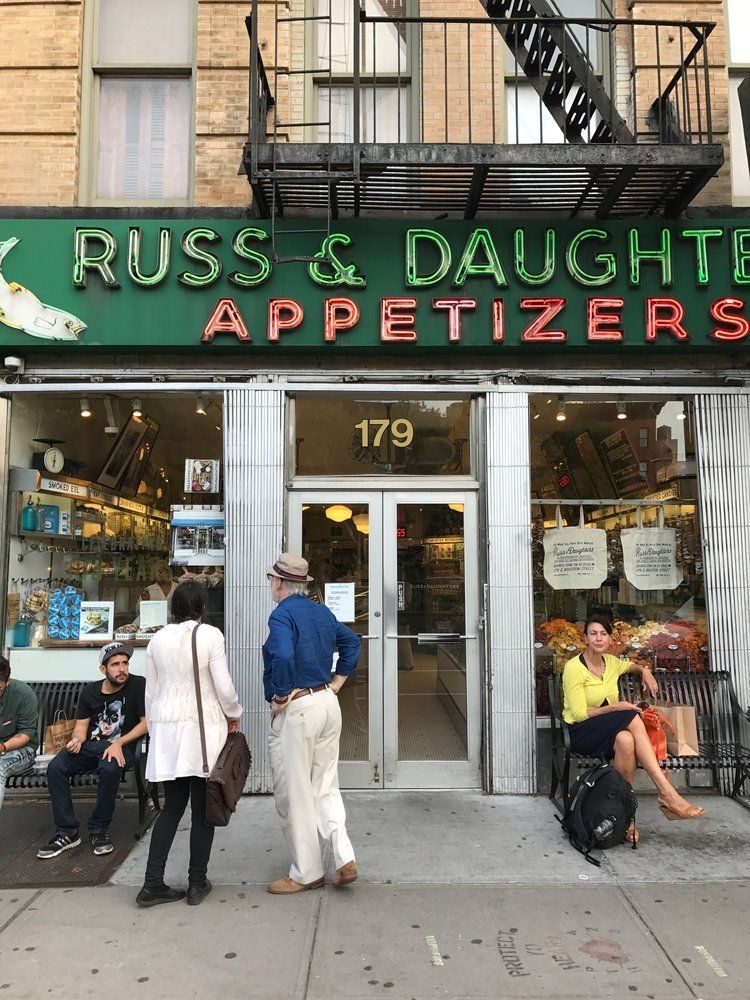 A group of people are standing outside of russ & daughters appetizers