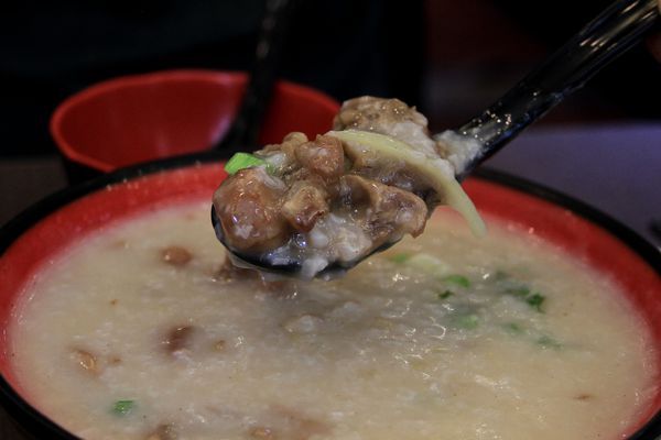 A close up of a bowl of soup with a spoon in it.