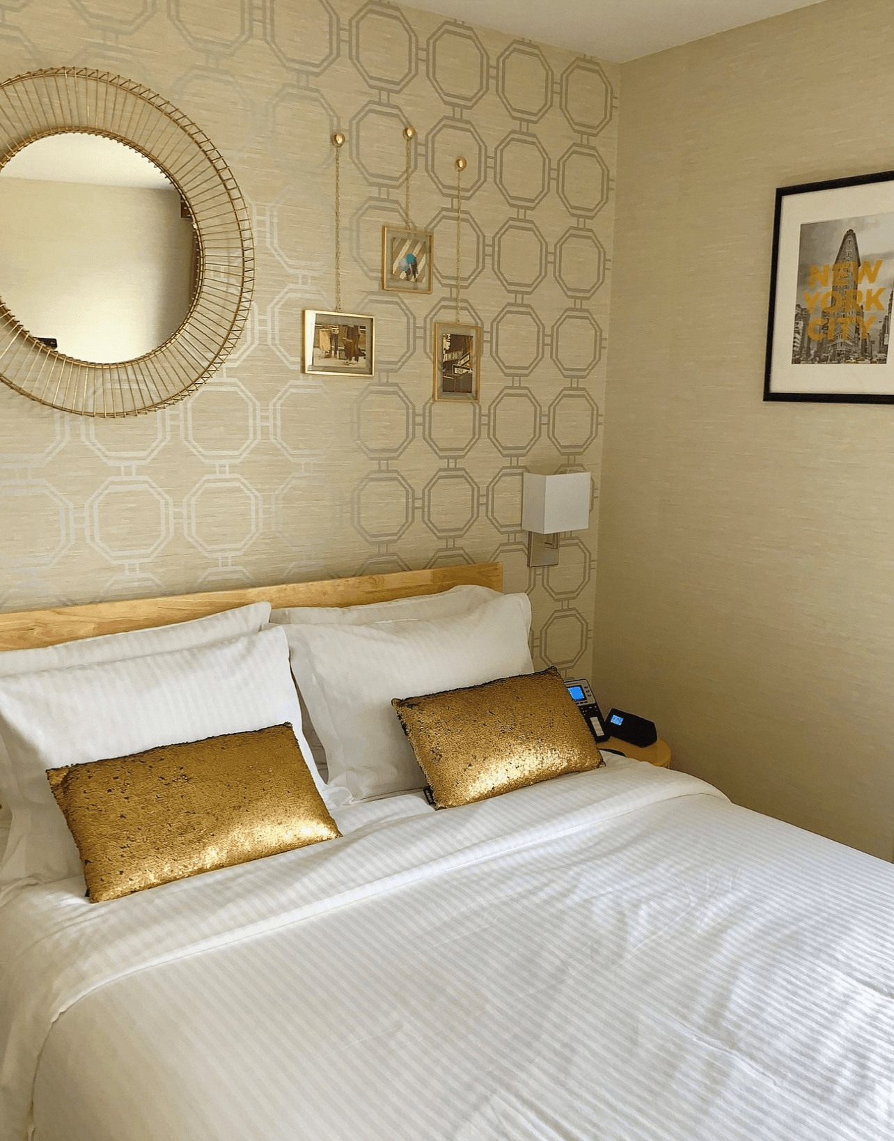 A bedroom with a bed , mirror and picture on the wall.