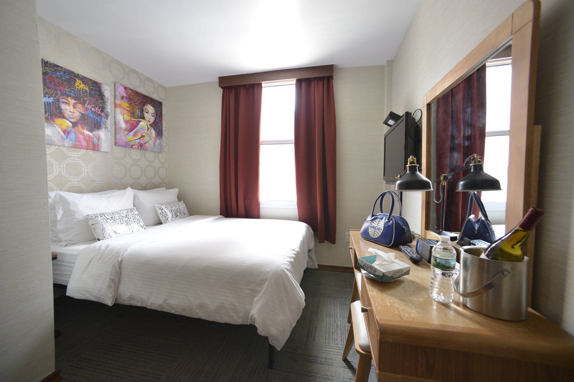 A hotel room with a large bed and a desk