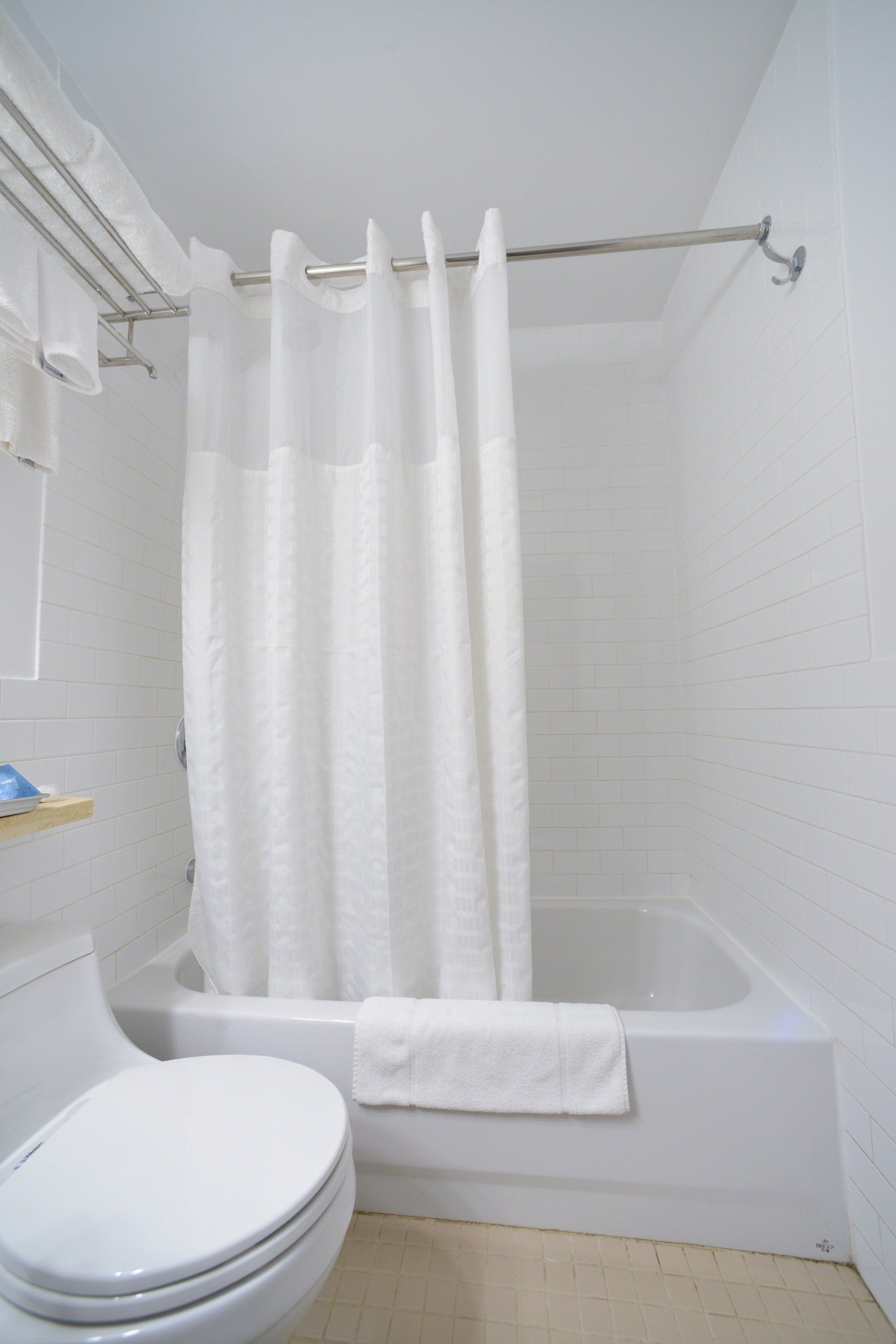 A bathroom with a toilet a bathtub and a shower curtain