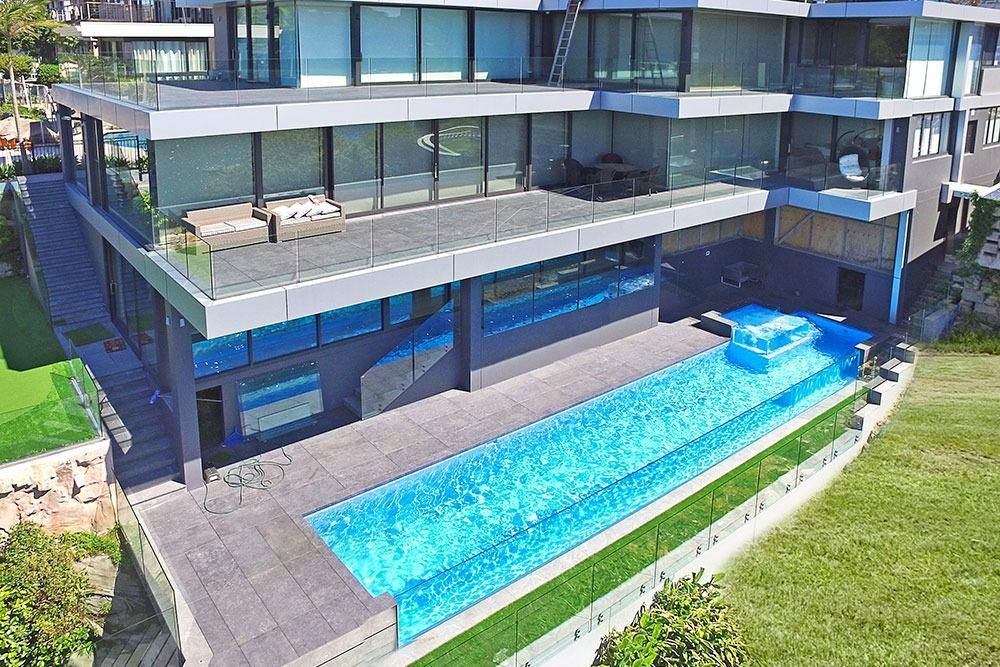 An Aerial View Of A Large House With A Swimming Pool In Front Of It — Dimension One Glass Fencing In Tuggerah, NSW