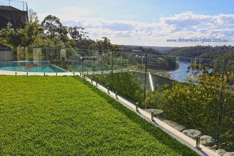 A Lush Green Lawn With A View Of A River And A Swimming Pool — Dimension One Glass Fencing In Tuggerah, NSW