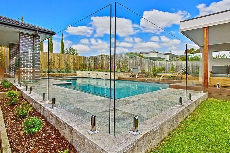 A Large Swimming Pool Is Surrounded By A Glass Fence — Dimension One Glass Fencing In Hunter Valley, NSW