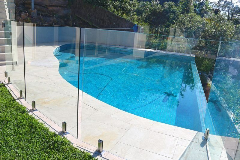 A Large Swimming Pool With A Glass Fence Around It — Dimension One Glass Fencing In Hunter Valley, NSW