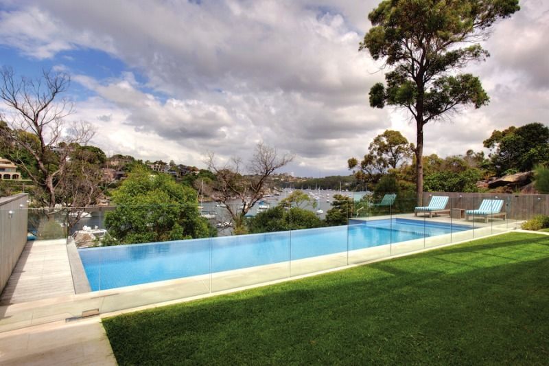 A Large Swimming Pool With A View Of A Body Of Water — Dimension One Glass Fencing In Hunter Valley, NSW