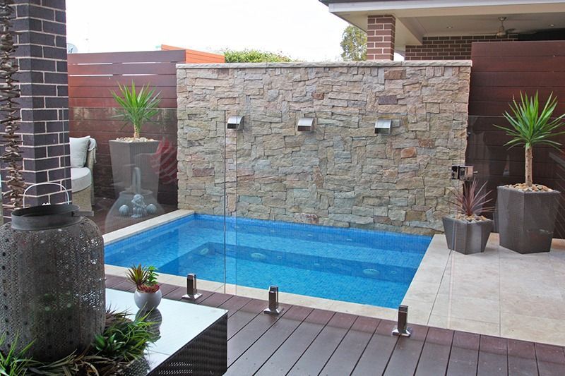 A Small Swimming Pool In The Backyard Of A House — Dimension One Glass Fencing In Tuggerah, NSW