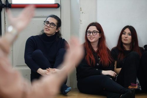 Tre persone sedute, in ascolto attento. Due portano gli occhiali. Una ha i capelli rossi. Dentro una stanza.