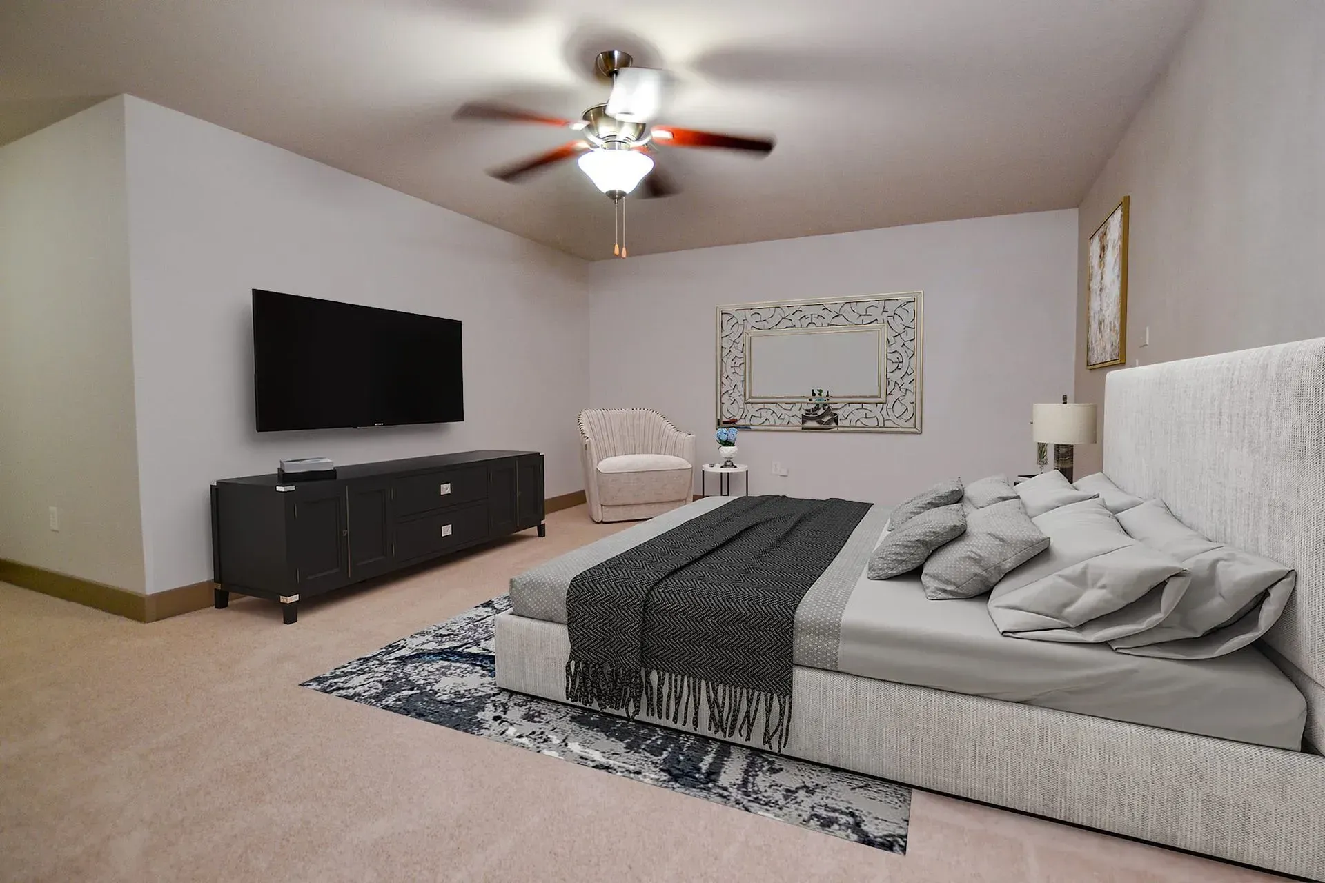Bedroom with a large bed, TV on a black cabinet, and a white armchair; neutral colors.