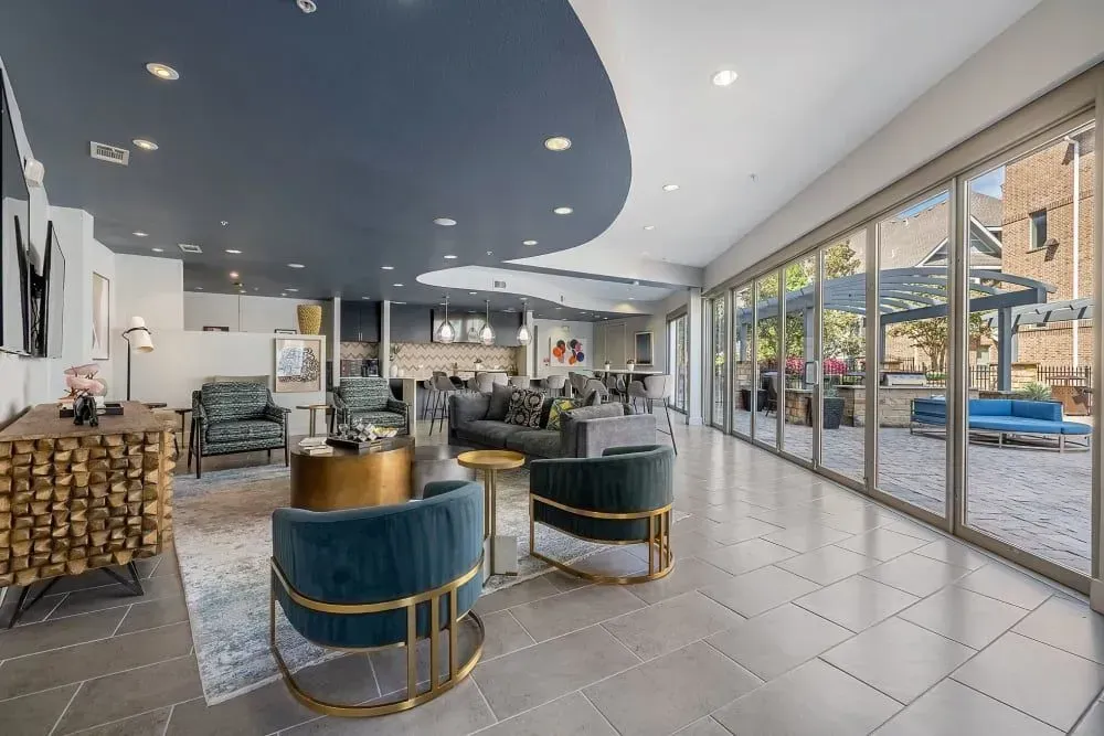 Stylish lounge area with blue ceiling, glass doors, and outdoor patio furniture.