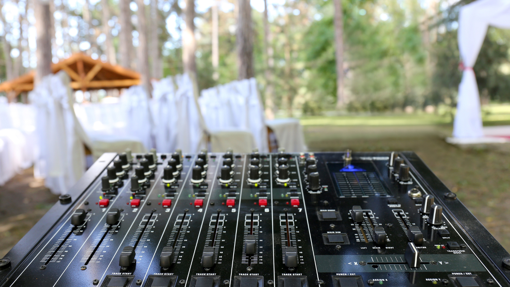A wedding DJ's sound board at an outdoor wedding venue in the Vermont woods.