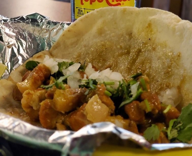 A close up of a plate of tacos on a table.
