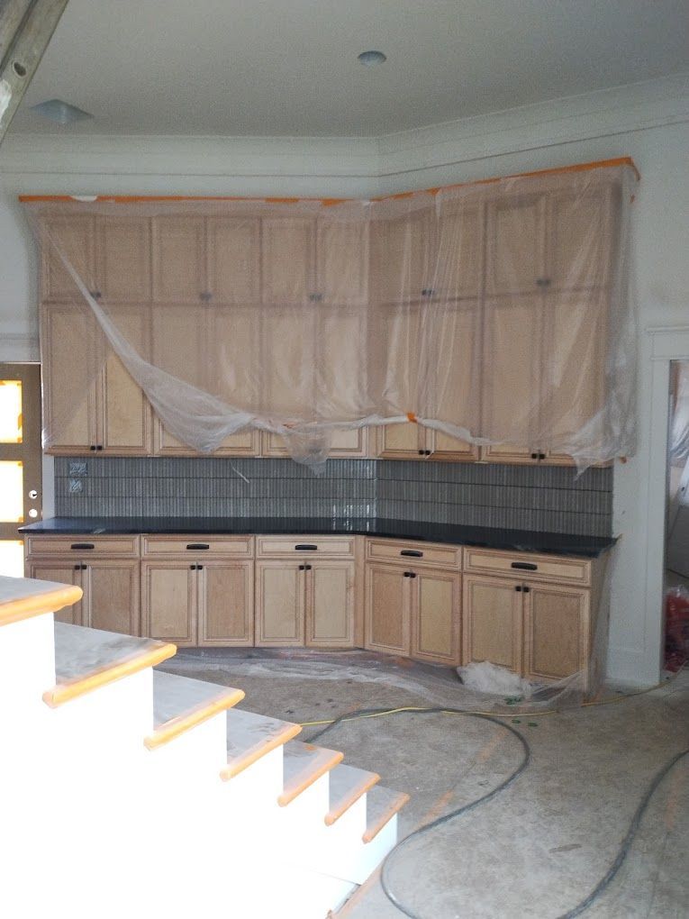 A kitchen with wooden cabinets and stairs under construction