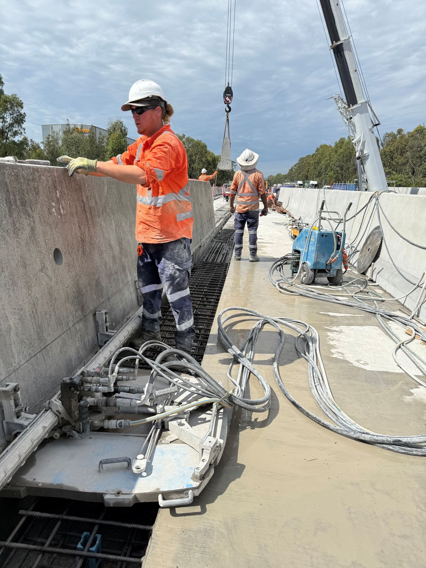 A person using a power saw cuts a white stone, creating a cloud of dust.
