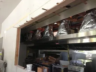 A kitchen with stainless steel appliances and a window.