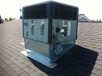 A large air conditioner is sitting on top of a roof.