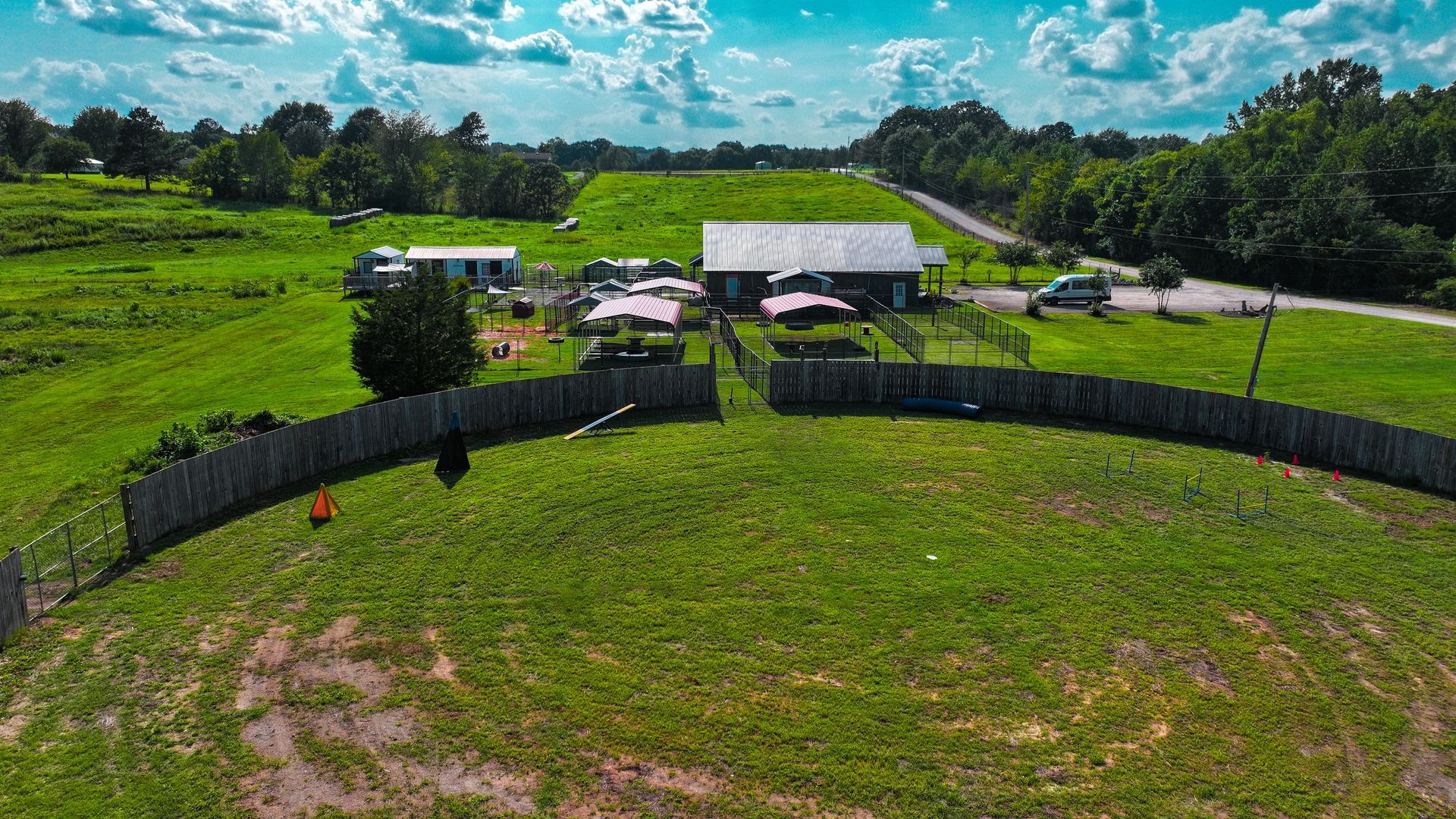 An aerial view of a house in the middle of a lush green field.