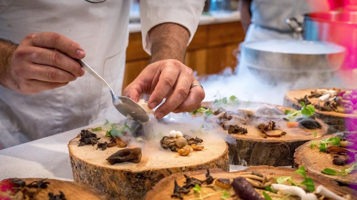 a chef is preparing food on a wooden stump .
