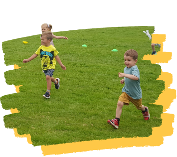 A group of children are running on a lush green field.