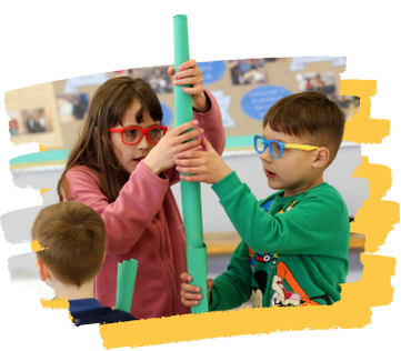 A boy and a girl are playing with a green tube