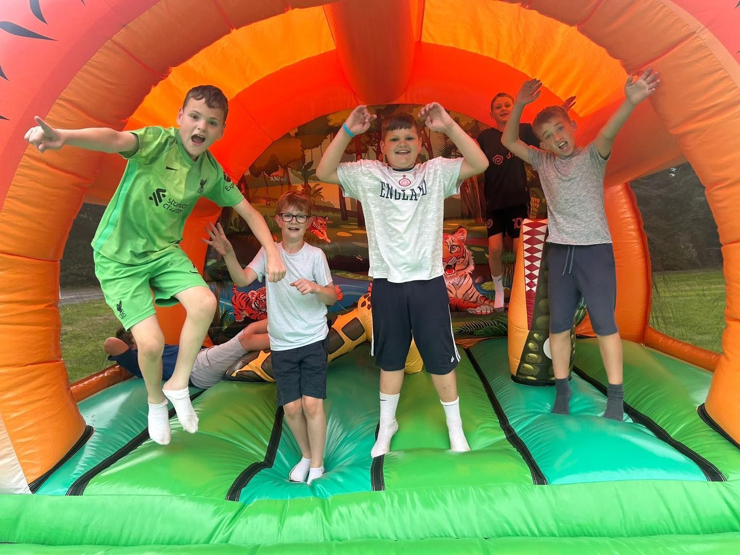 A group of young boys are jumping in a bouncy castle.