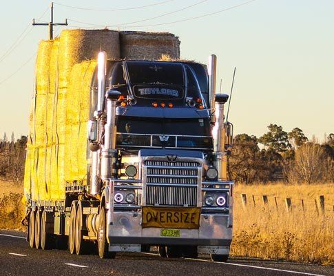 large semi truck moving hay barrel