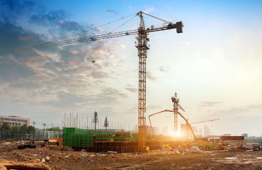 A construction site with a crane and a concrete pump.